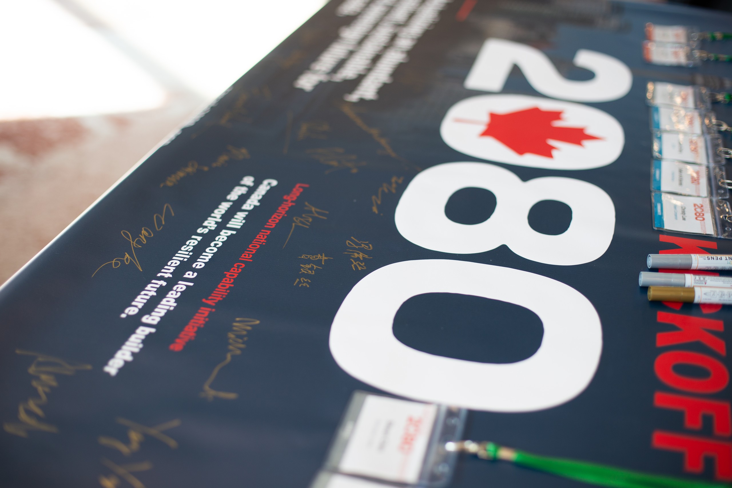 Close view of handwritten signatures on the Canada2080 kickoff banner.