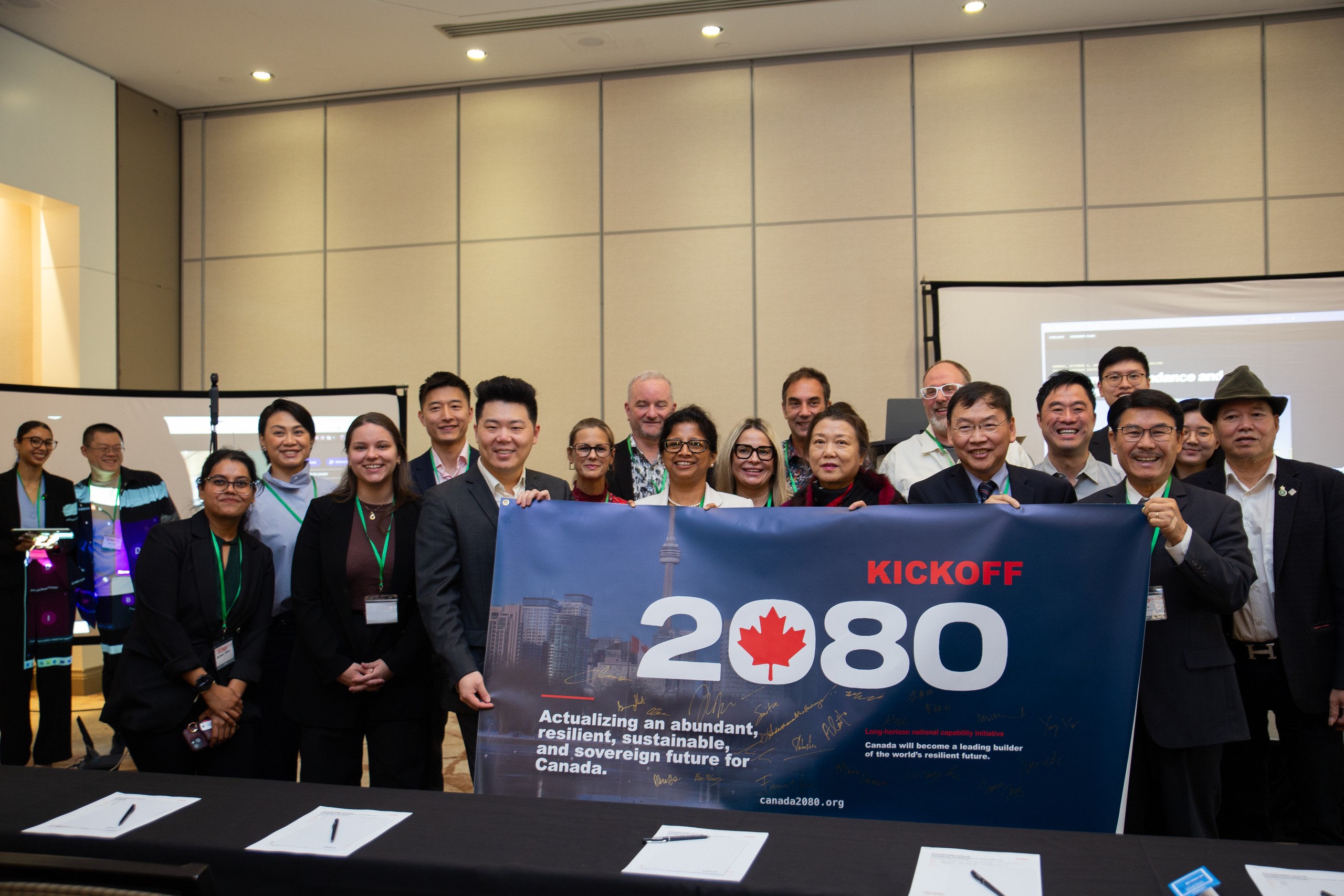Speakers and guests hold the signed Canada2080 kickoff banner in the Markham Ballroom.