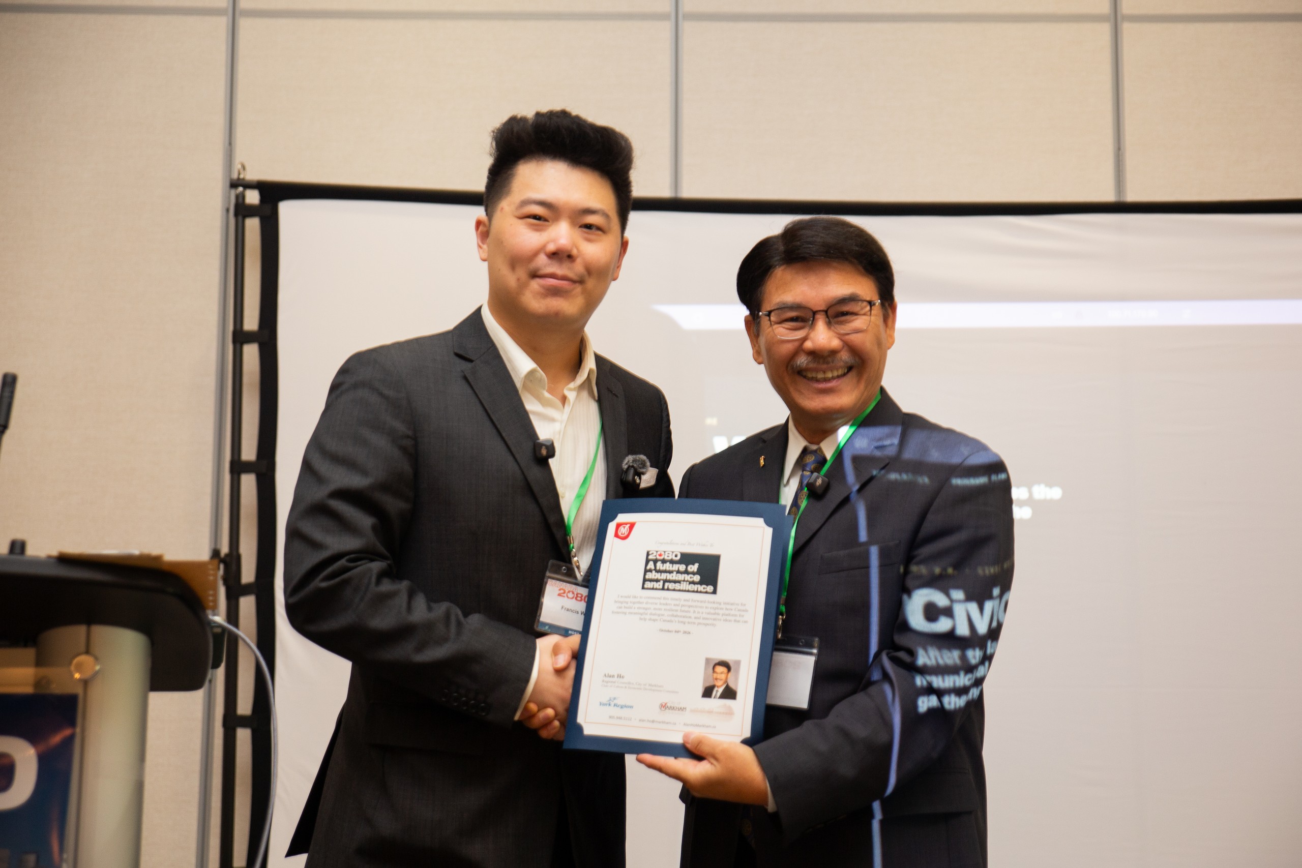 Francis Wang and Alan Ho hold a framed City of Markham proclamation for the Canada2080 kickoff.