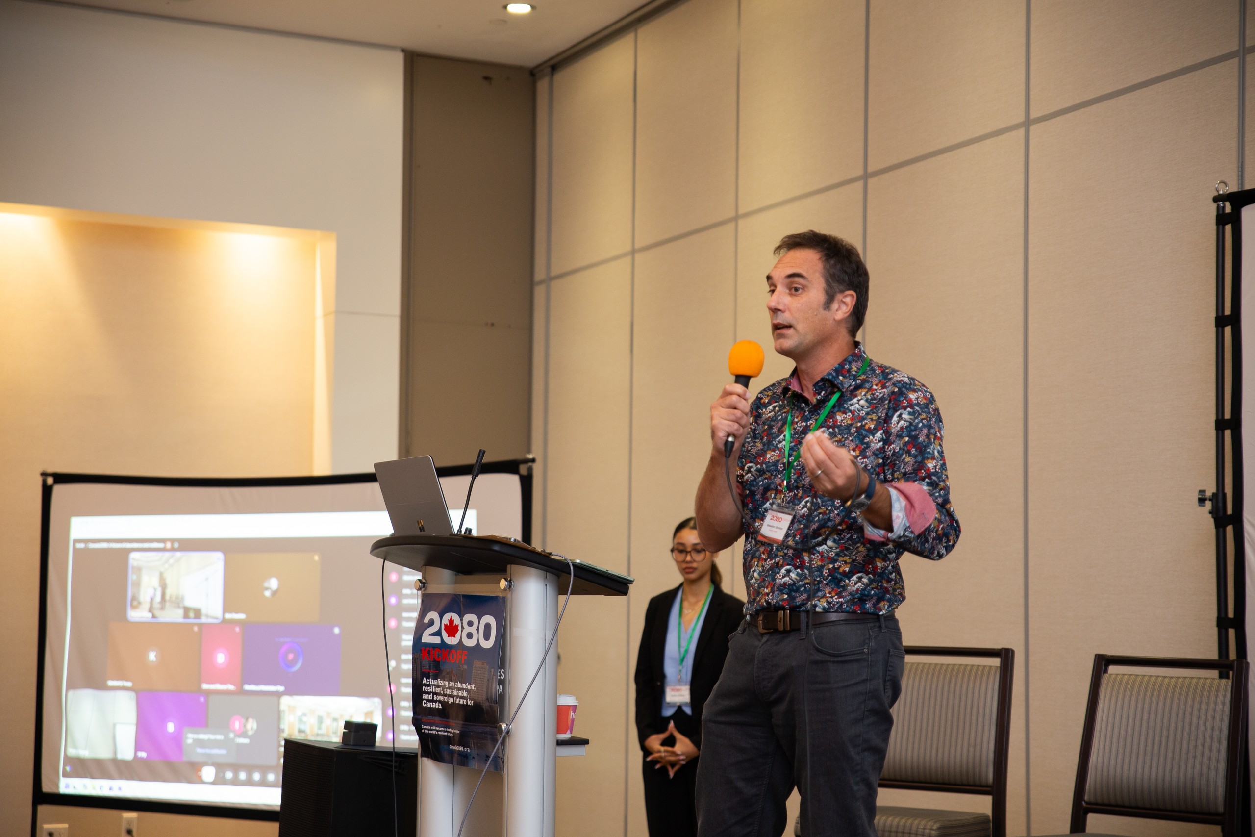 Sebastien Gendron speaking with an orange microphone.